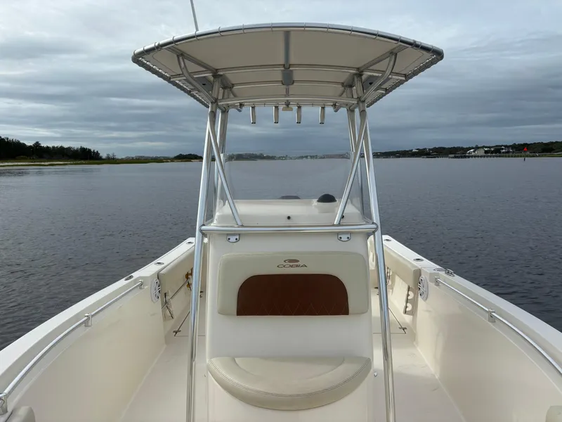 Slide: The Image of 2022 Cobia 237 Center Console boat on calm water under cloudy sky. - 15