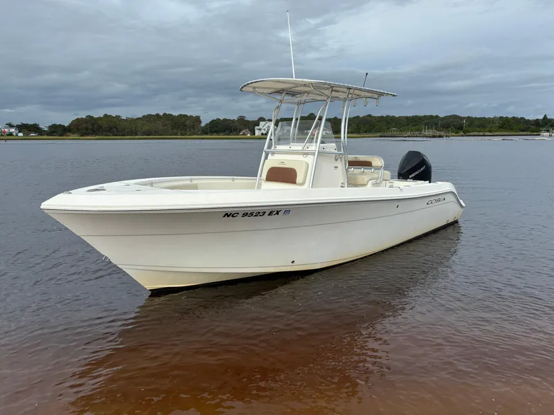 Slide: The Image of 2022 Cobia 237 Center Console boat on calm water, overcast sky. - 2