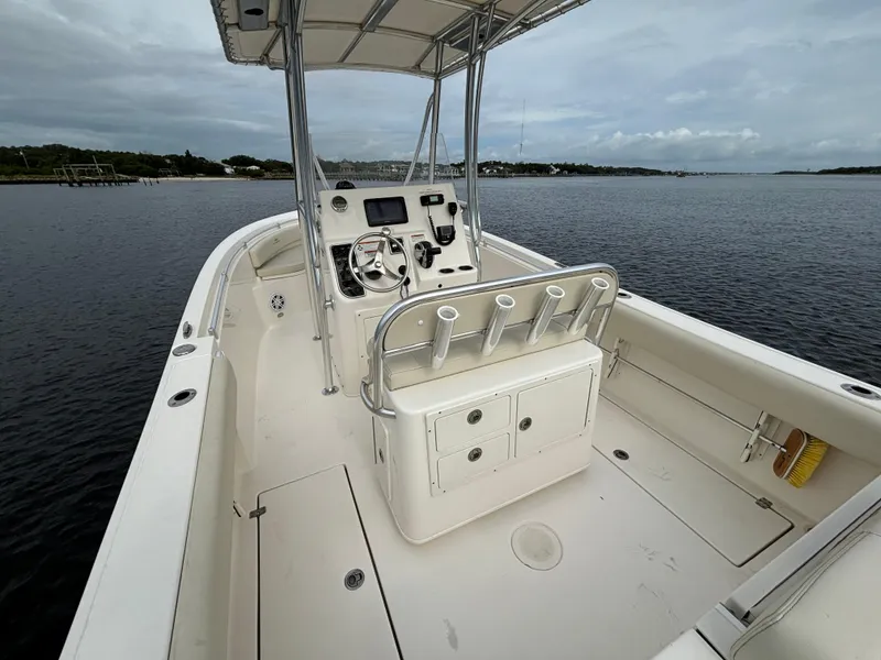 Slide: The Image of 2022 Cobia 237 Center Console boat on calm water, featuring a spacious deck and helm. - 25