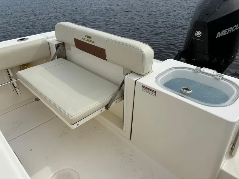 Slide: The Image of 2022 Cobia 237 Center Console boat with seating and livewell, on calm water. - 27