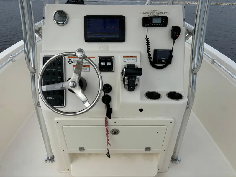 Slide: The Image of Cobia 237 Center Console 2022 boat dashboard with steering wheel and navigation equipment. - 39