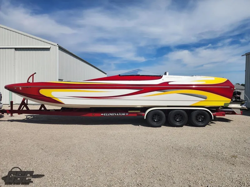 The Image of 2005 Eliminator Daytona 30 speedboat with vibrant red, yellow, and white design on a trailer. - 1
