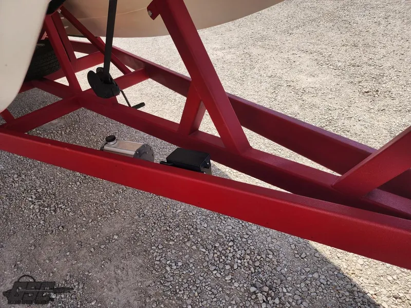 Slide: The Image of Red trailer frame for 2005 Eliminator Daytona 30 boat on gravel surface. - 19