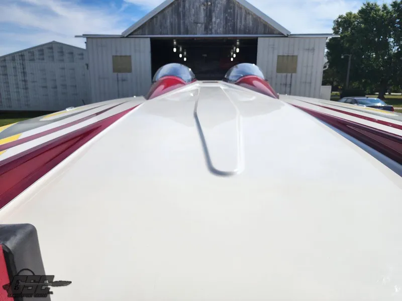Slide: The Image of 2005 Eliminator Daytona 30 boat, sleek design, parked near a barn under a blue sky. - 20