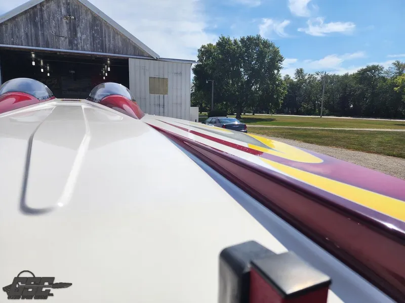 Slide: The Image of 2005 Eliminator Daytona 30 boat outside a barn, sunny day, trees in background. - 22