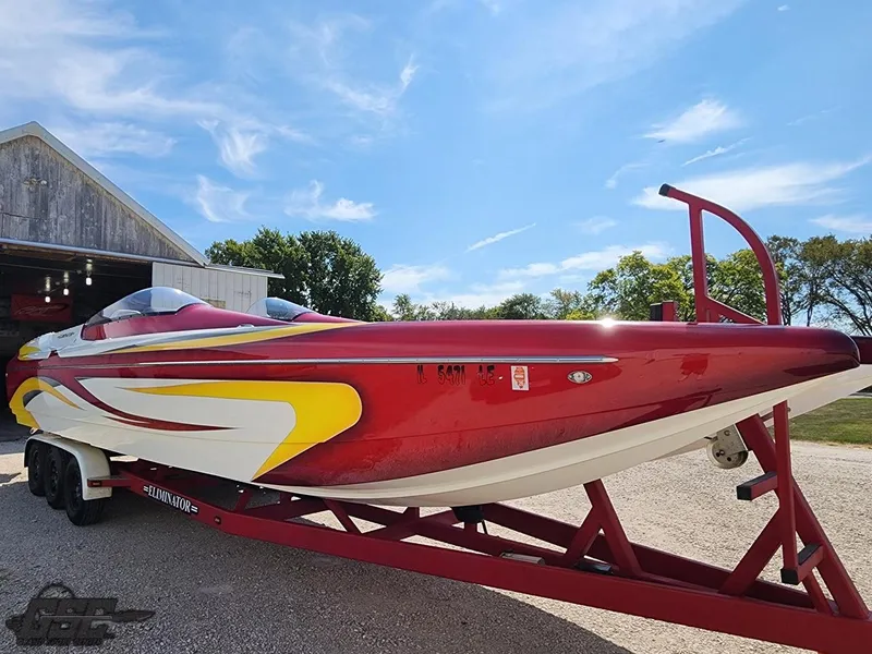 Slide: The Image of 2005 Eliminator Daytona 30 speedboat on trailer, vibrant red and yellow design. - 24