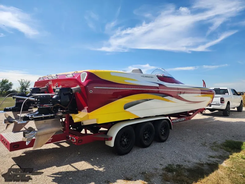 Slide: The Image of 2005 Eliminator Daytona 30 speedboat on trailer, vibrant red and yellow design, parked outdoors. - 26