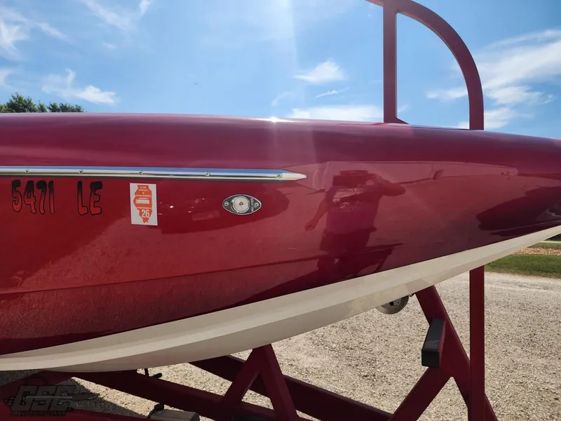 Slide: The Image of Red 2005 Eliminator Daytona 30 boat on trailer under blue sky. - 27