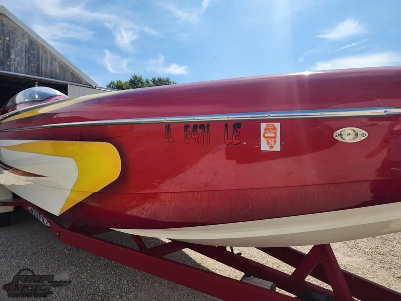 Slide: The Image of Red 2005 Eliminator Daytona 30 boat on trailer under blue sky. - 28
