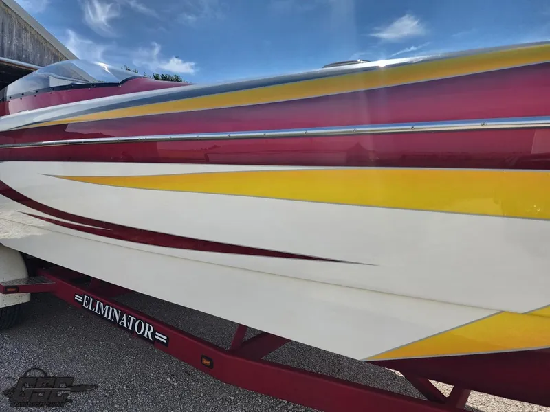 Slide: The Image of 2005 Eliminator Daytona 30 boat with vibrant red, yellow, and white design. - 29