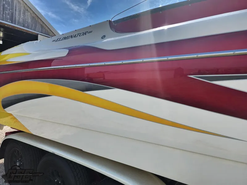 Slide: The Image of 2005 Eliminator Daytona 30 boat with vibrant red, yellow, and white design. - 31