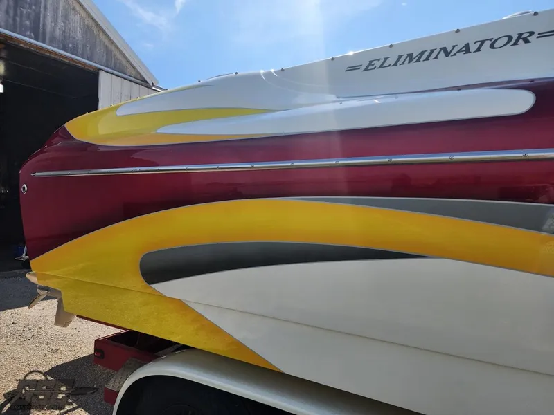 Slide: The Image of 2005 Eliminator Daytona 30 boat with vibrant red, yellow, and white design. - 32