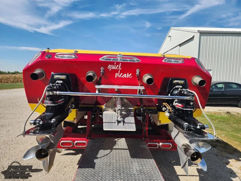 Slide: The Image of 2005 Eliminator Daytona 30 boat with dual engines, vibrant red and yellow design. - 37