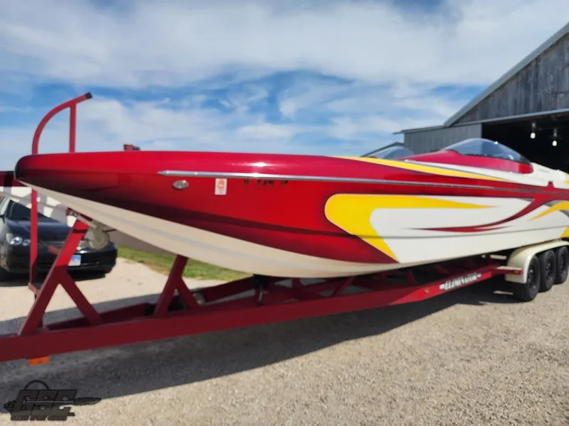 Slide: The Image of 2005 Eliminator Daytona 30 speedboat on trailer, red and yellow design, parked outdoors. - 4