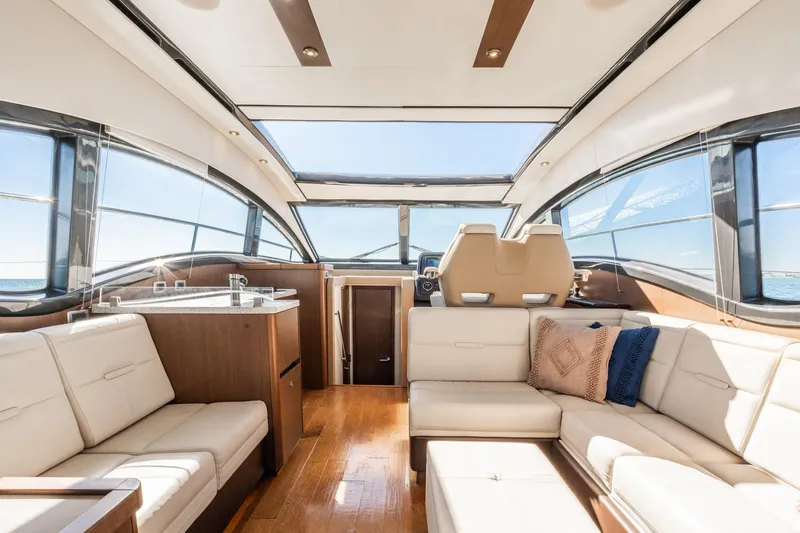 Slide: The Image of Luxurious interior of 2016 Sea Ray 400 Sundancer yacht with plush seating and panoramic windows. - 13