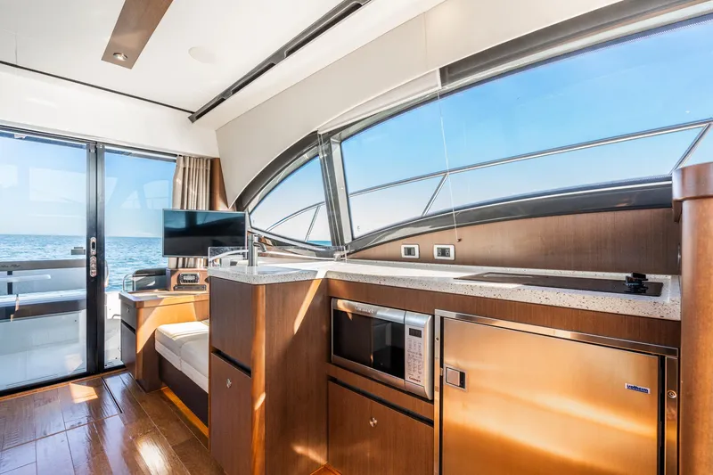 Slide: The Image of Interior of 2016 Sea Ray 400 Sundancer yacht with modern kitchen and ocean view. - 17