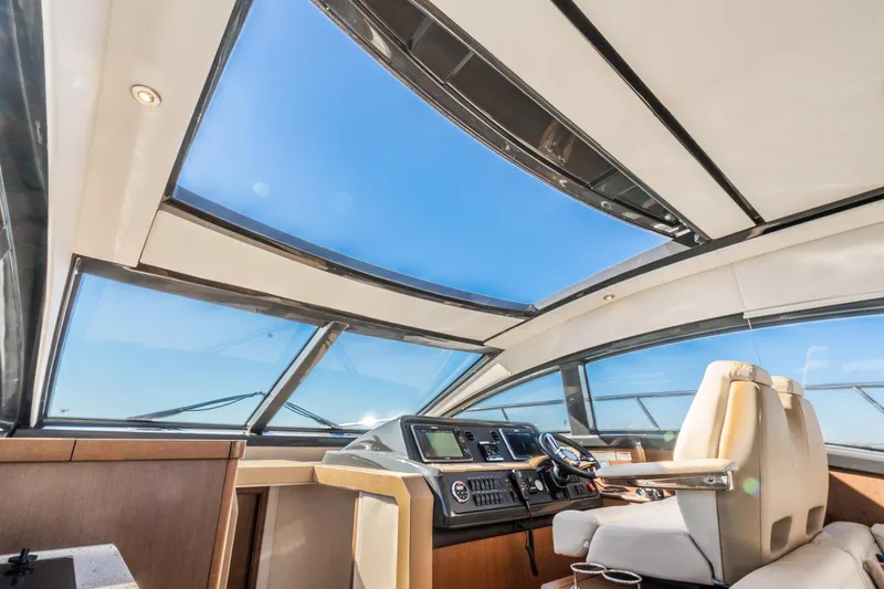 Slide: The Image of Interior view of 2016 Sea Ray 400 Sundancer yacht with panoramic windows and modern helm. - 19