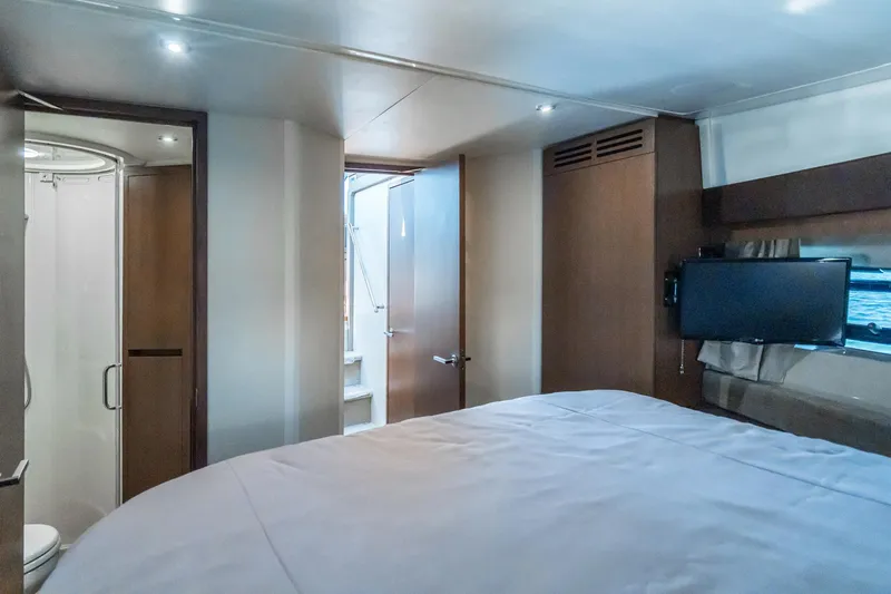 Slide: The Image of Interior of 2016 Sea Ray 400 Sundancer yacht bedroom with TV and ensuite bathroom. - 25