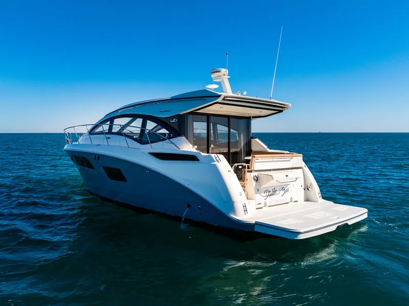 Slide: The Image of 2016 Sea Ray 400 Sundancer yacht on open water under clear blue sky. - 5