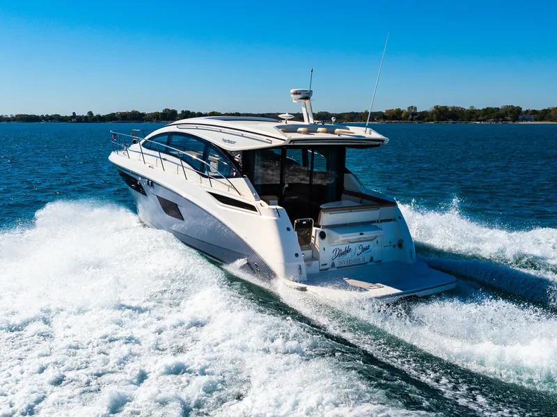 Slide: The Image of 2016 Sea Ray 400 Sundancer cruising on a sunny day, creating waves in blue water. - 7