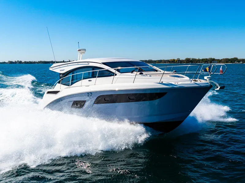 Slide: The Image of 2016 Sea Ray 400 Sundancer cruising on open water under clear blue skies. - 9