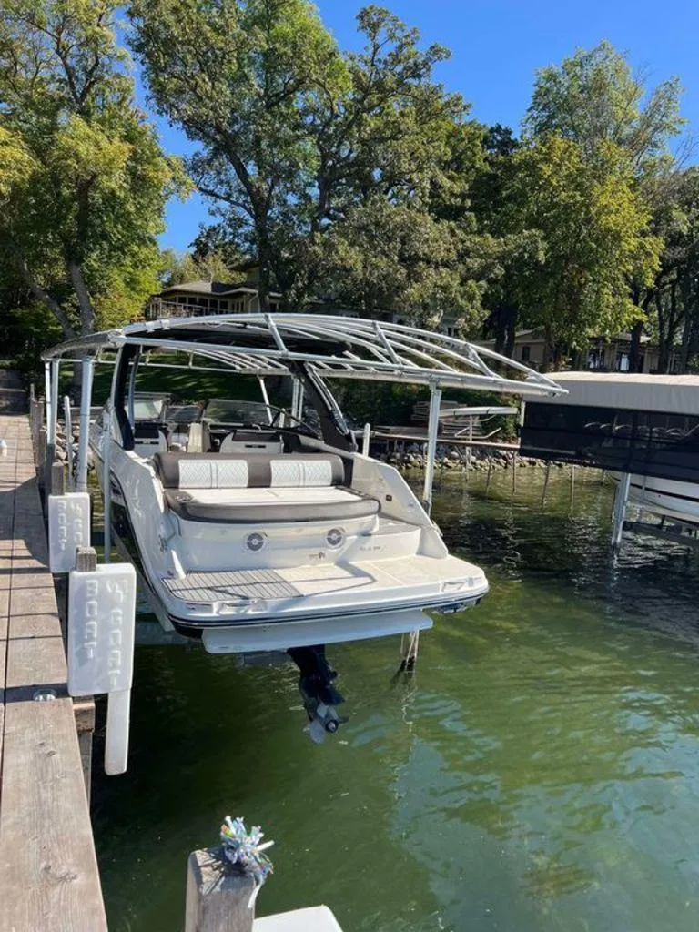 Slide: The Image of 2017 Sea Ray SLX 280 boat docked on a serene lake with lush trees. - 2