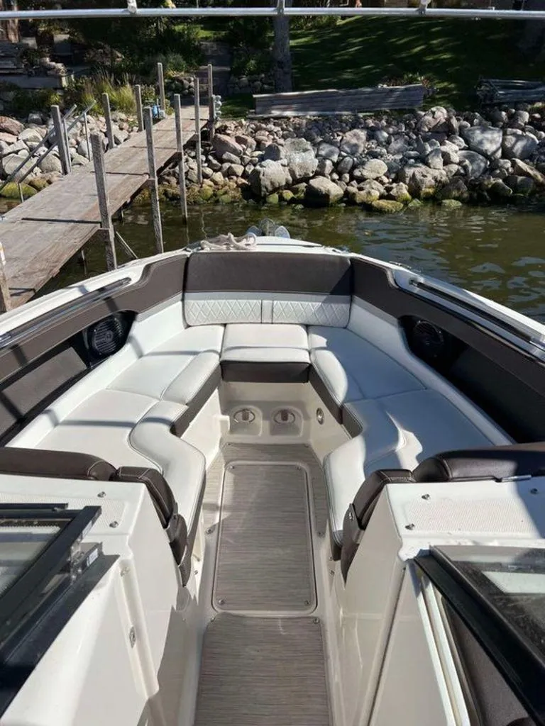 Slide: The Image of 2017 Sea Ray SLX 280 boat interior with white seating, dockside view. - 7