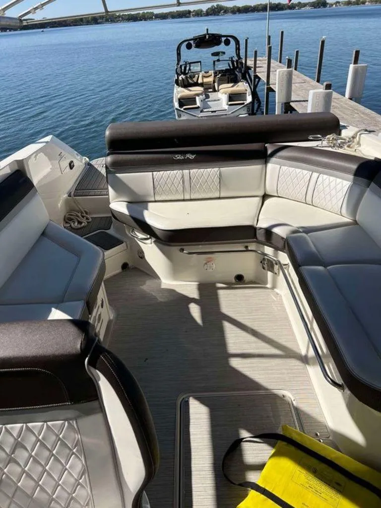 Slide: The Image of 2017 Sea Ray SLX 280 boat interior with luxurious seating, docked by a serene lake. - 9