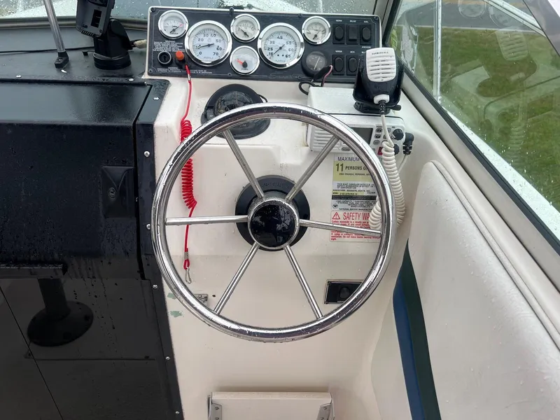 Slide: The Image of 1998 Seaswirl Striper 2150 Walkaround boat dashboard with steering wheel and gauges. - 4