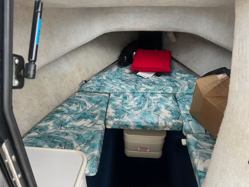 Slide: The Image of 1998 Seaswirl Striper 2150 Walkaround cabin interior with patterned cushions and storage. - 6