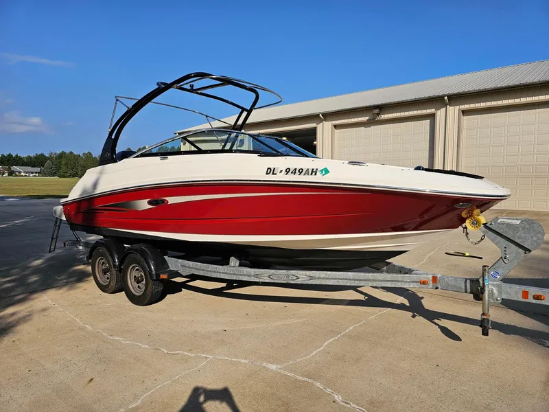 Slide: The Image of 2014 Sea Ray 220 Sundeck Outboard on trailer, red and white design, parked outdoors. - 3