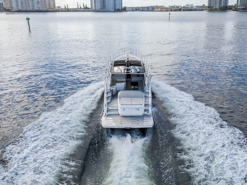 Slide: The Image of 2020 Azimut Atlantis 45 yacht cruising on open water, cityscape in background. - 8