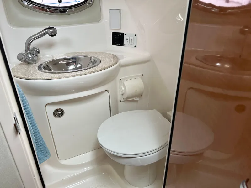 Slide: The Image of 2007 Chaparral Signature 250 boat bathroom with sink, toilet, and storage cabinet. - 16