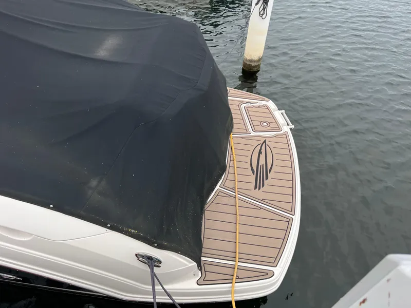 Slide: The Image of 2007 Chaparral Signature 250 boat with covered deck, docked by the water. - 18