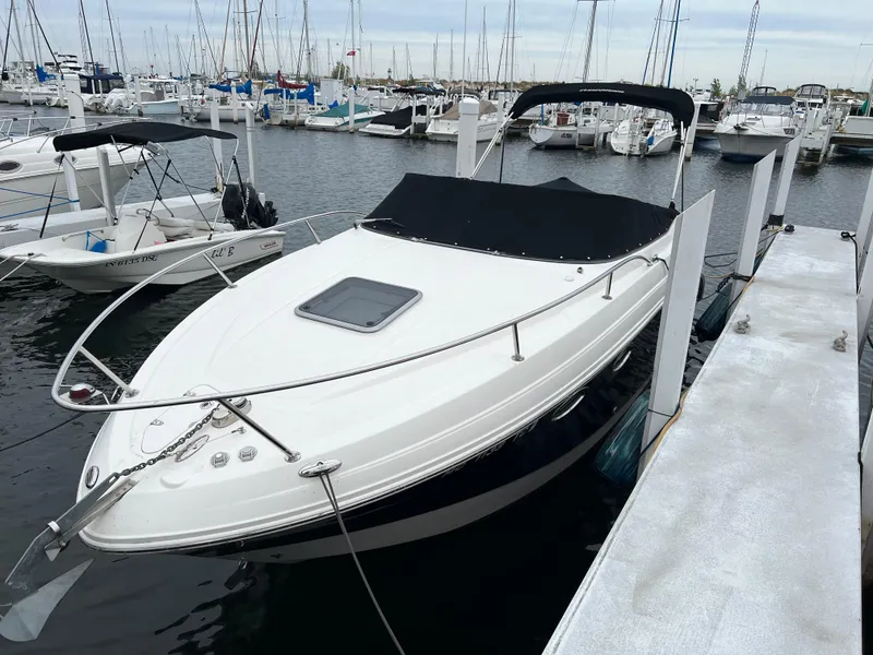 Slide: The Image of 2007 Chaparral Signature 250 boat docked at a marina, featuring a sleek white design. - 2