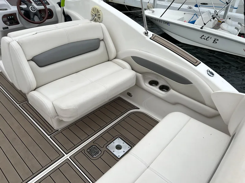 Slide: The Image of 2007 Chaparral Signature 250 boat interior with white seating and wood-style flooring. - 7