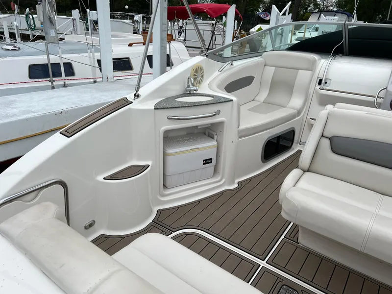 Slide: The Image of 2007 Chaparral Signature 250 boat interior with seating and storage, featuring sleek white and gray design. - 8