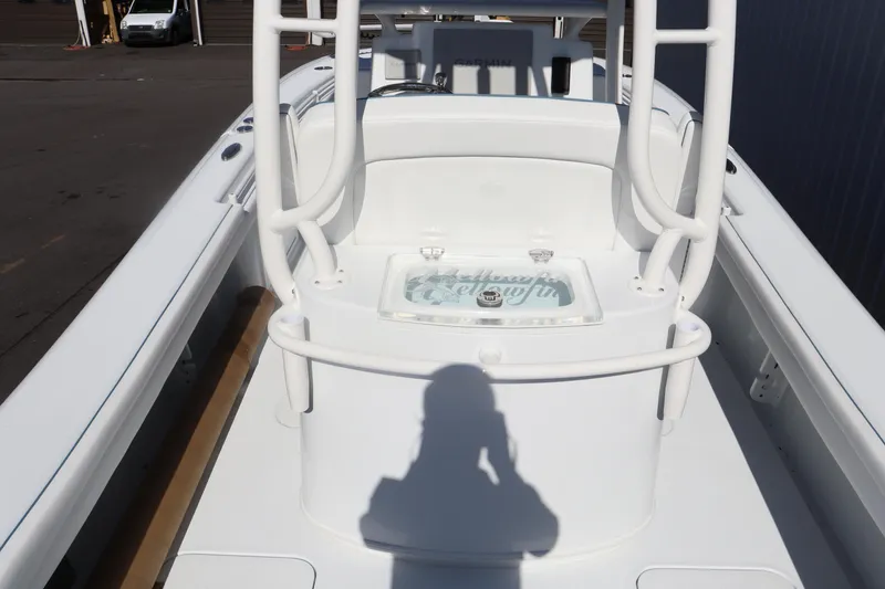 Slide: The Image of 2025 Yellowfin 26 Hybrid boat deck with white seating and storage area. - 13
