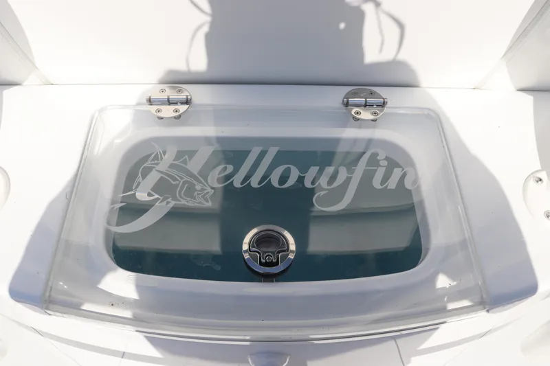 Slide: The Image of 2025 Yellowfin 26 Hybrid livewell with logo on transparent lid. - 26