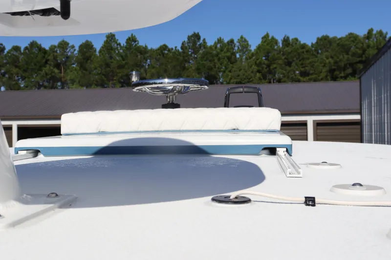 Slide: The Image of 2025 Yellowfin 26 Hybrid boat deck with seating, surrounded by trees and buildings. - 33