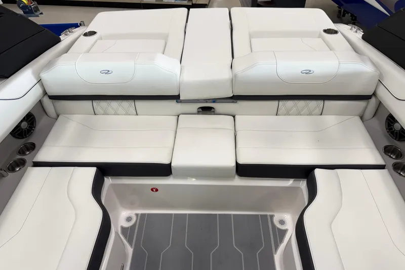 Slide: The Image of 2025 Regal LS2 Surf boat interior with white cushioned seating and cup holders. - 21