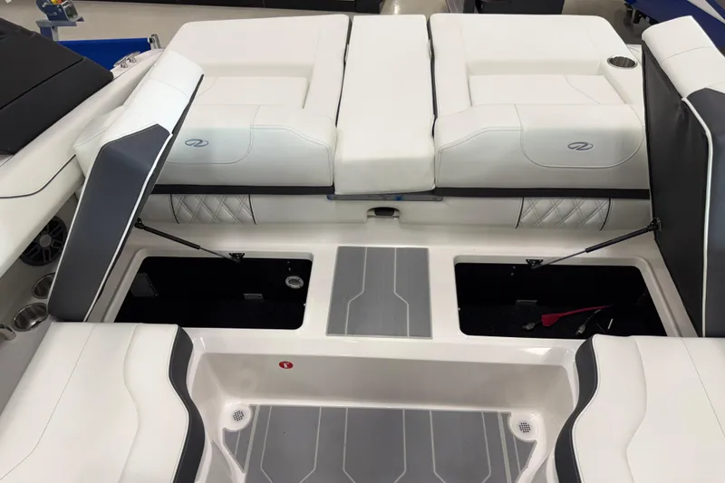 Slide: The Image of 2025 Regal LS2 Surf boat interior with white and gray seating and storage compartments. - 22