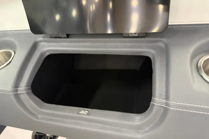 Slide: The Image of 2025 Regal LS2 Surf boat storage compartment with cup holders and sleek design. - 47
