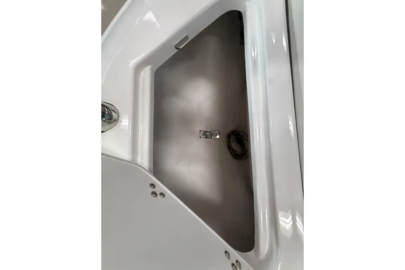 Slide: The Image of 2025 Regal LS2 Surf boat storage compartment, white interior, open lid view. - 56