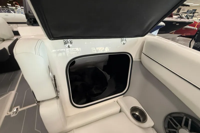 Slide: The Image of 2025 Regal LS2 Surf boat interior storage compartment with open lid and cup holder. - 60