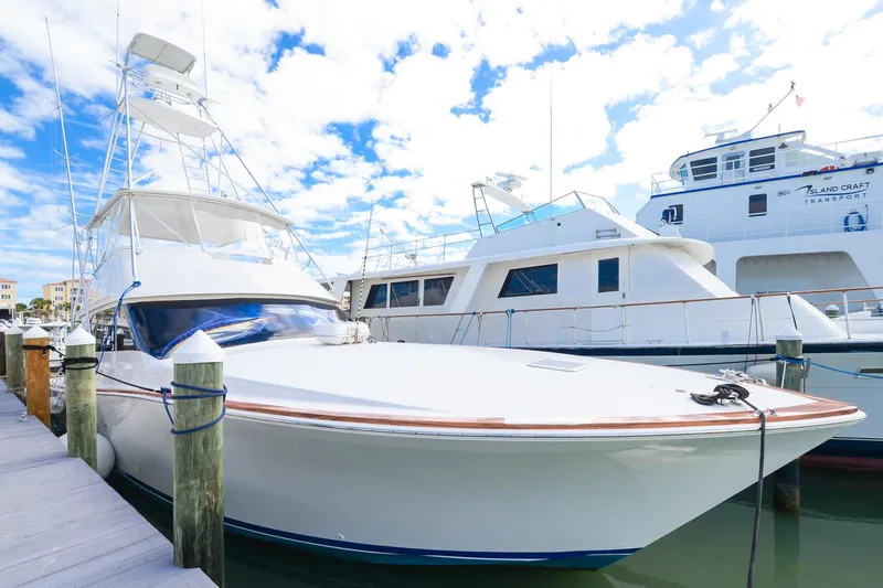 The Image of 1999 Viking 55 Convertible yacht docked at marina under blue sky. - 0