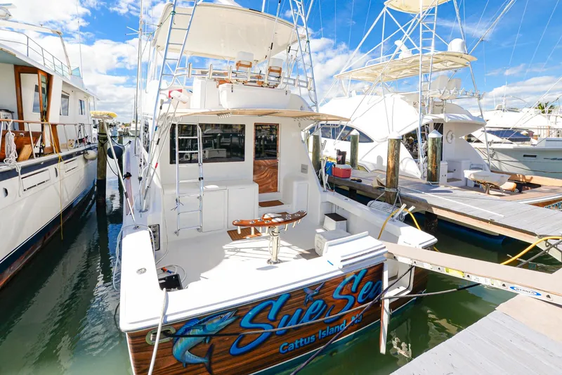 Slide: The Image of 1999 Viking 55 Convertible yacht docked at marina under clear blue sky. - 2
