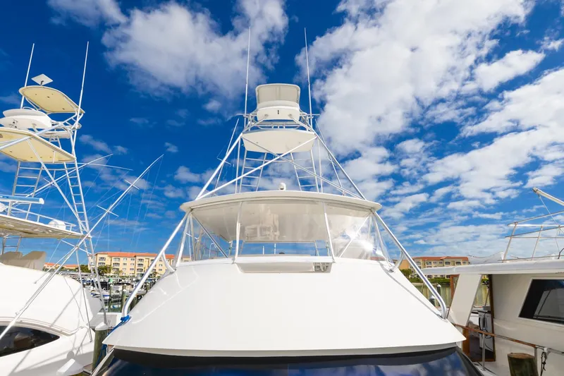 Slide: The Image of 1999 Viking 55 Convertible yacht with tower against a vibrant blue sky and clouds. - 28