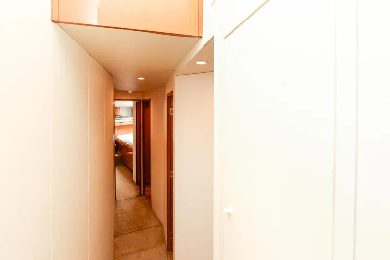 Slide: The Image of Narrow hallway inside 1999 Viking 55 Convertible yacht with wooden doors and soft lighting. - 44