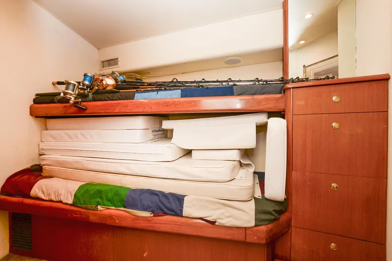 Slide: The Image of Interior of 1999 Viking 55 Convertible with stacked mattresses and fishing rods. - 47